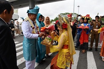 Tiba di Bandara Kualanamu, Pj Gubsu Dipakaikan Kain Melayu